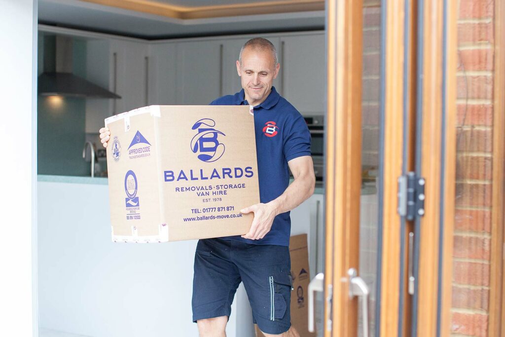 Ballards Removals staff carrying box during house move