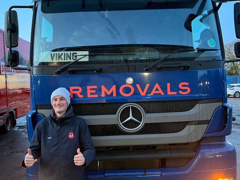 ballards removals truck and man holding two thumbs up