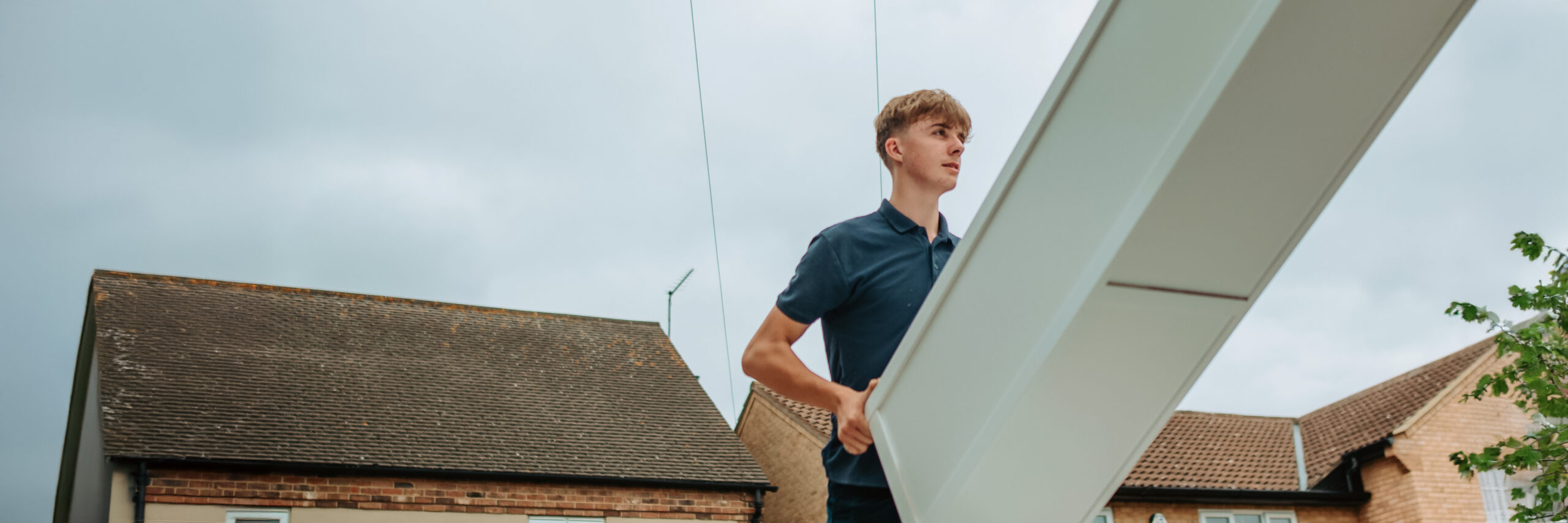 Ballards removal team member carrying a white cabinet in a house removal
