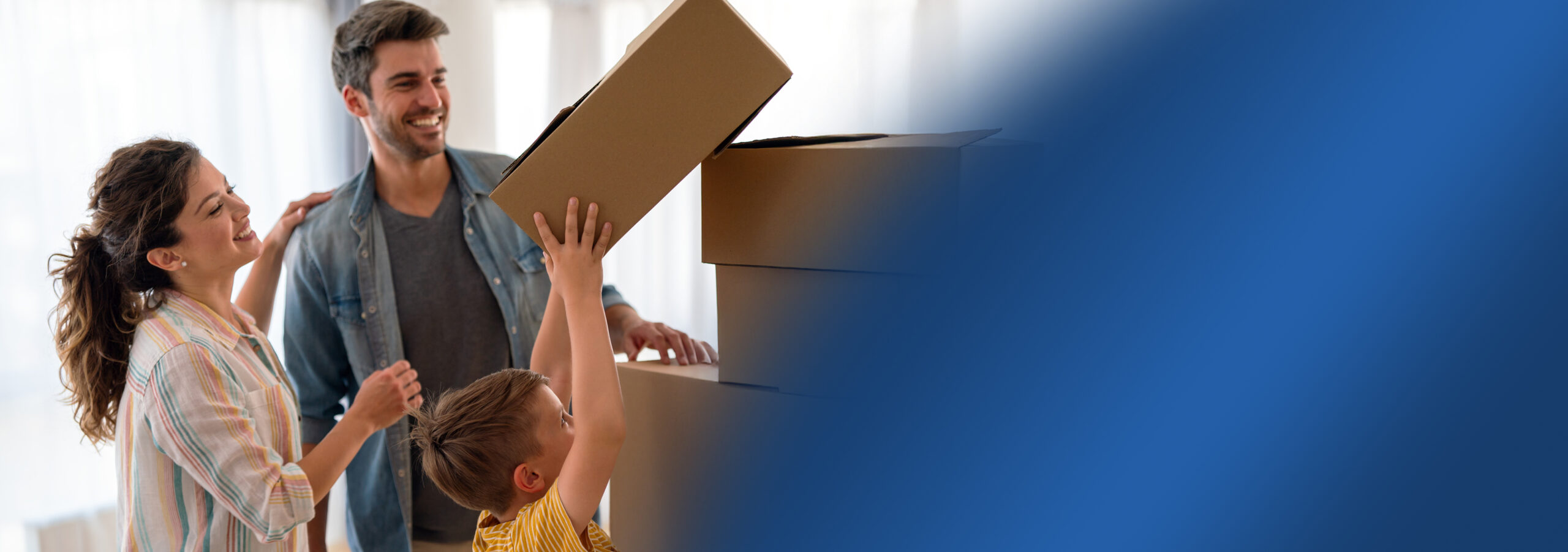 A child helping their parents stack removal boxes in a pile