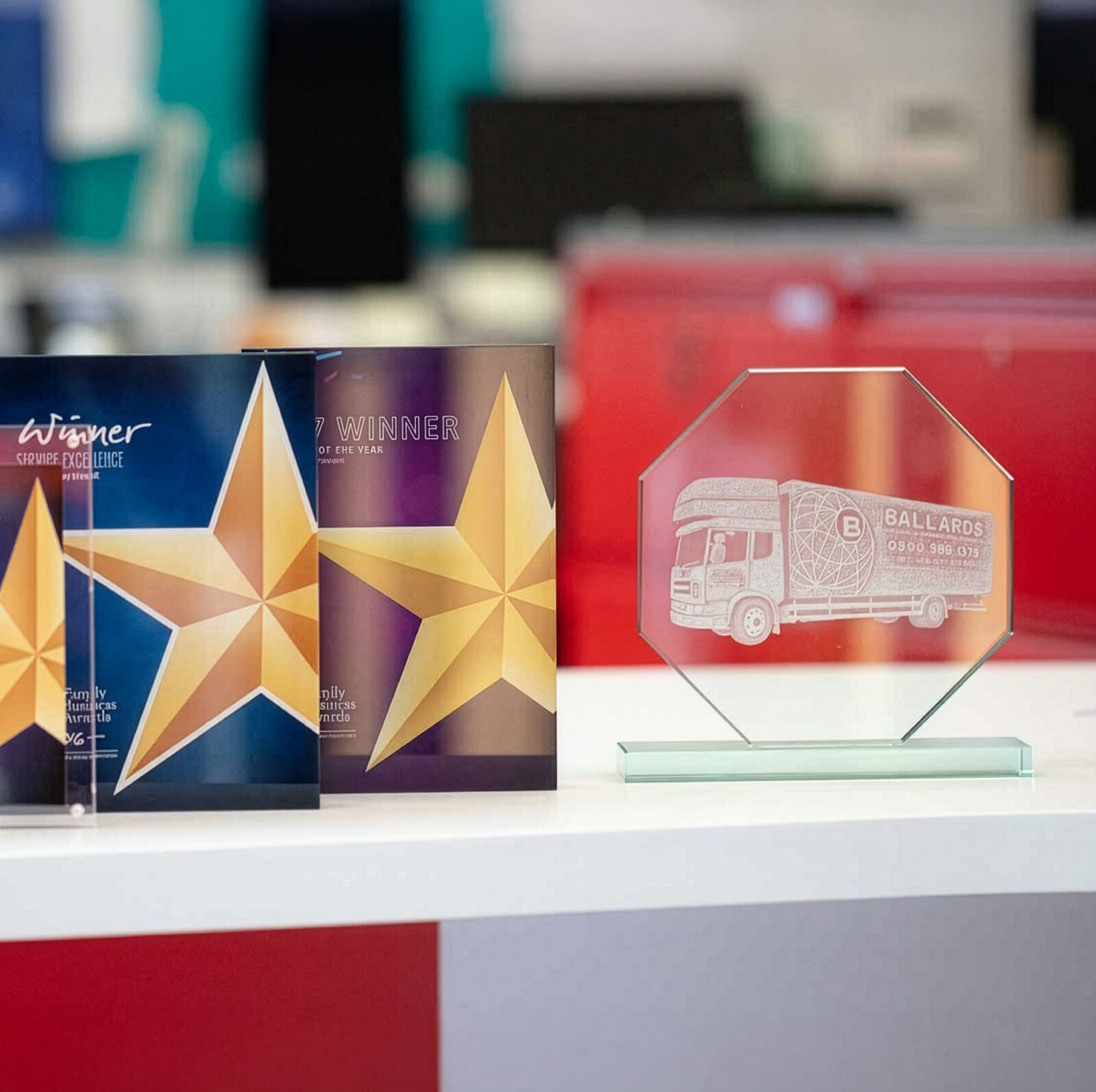 An image showcasing Ballards awards. There are 3 star awards, and a plaque showing an ballards removals truck etched into the glass.