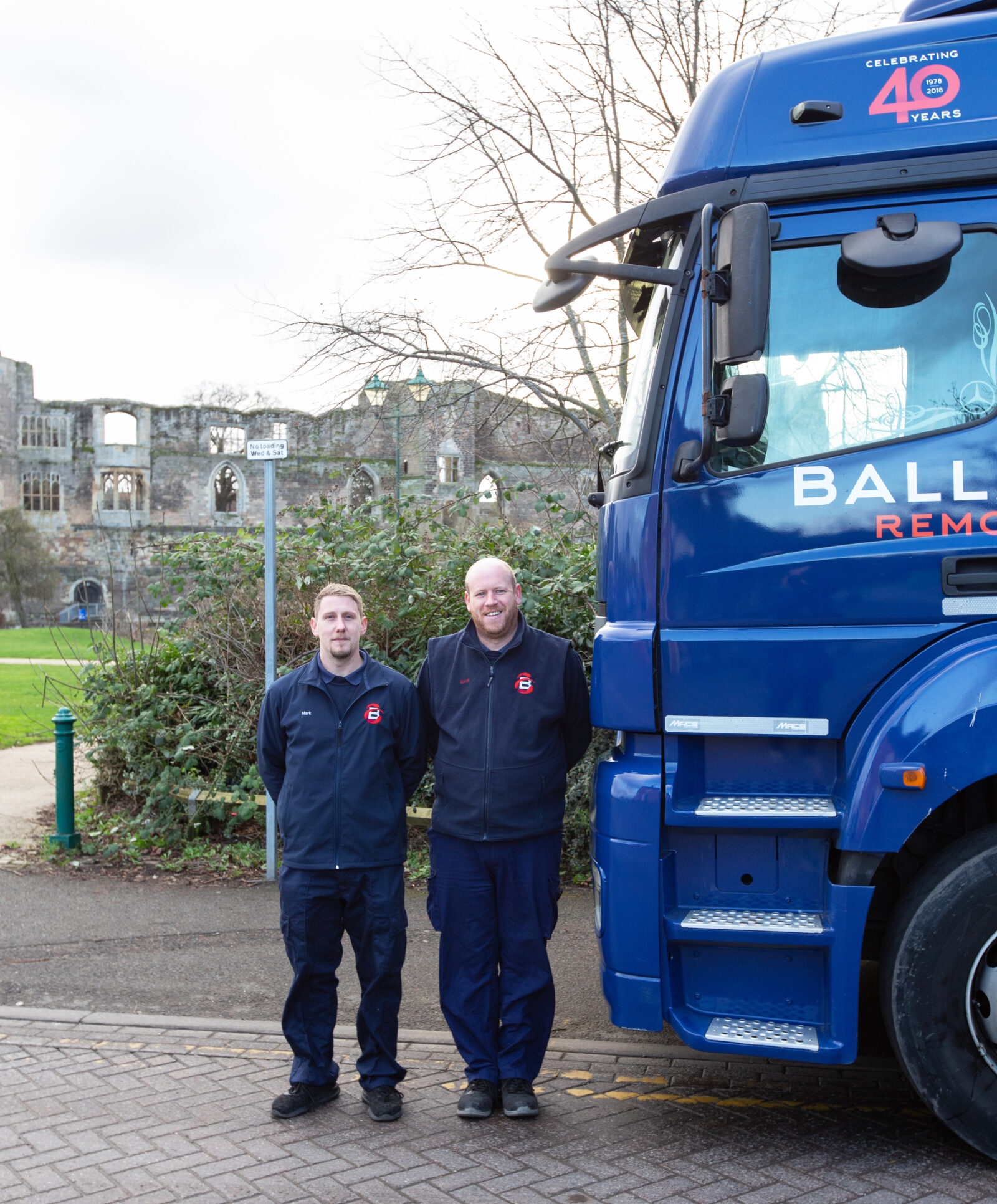 Two Ballards Removals team members standing beside a Ballards truck in Newark.