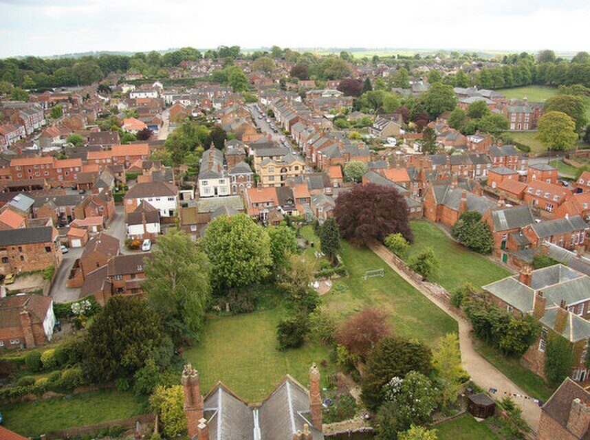 Elevated view looking across Louth, showing the town’s rooftops, St James’s Church spire and surrounding landscape under clear daylight.