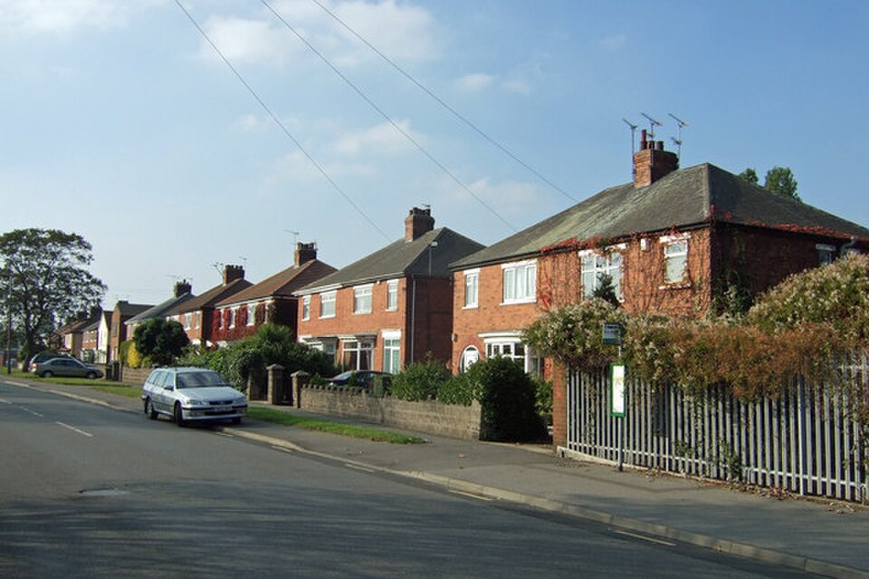 Typical semi‑detached houses along Rowland Road in Scunthorpe, North Lincolnshire, shown from street level on a clear day.