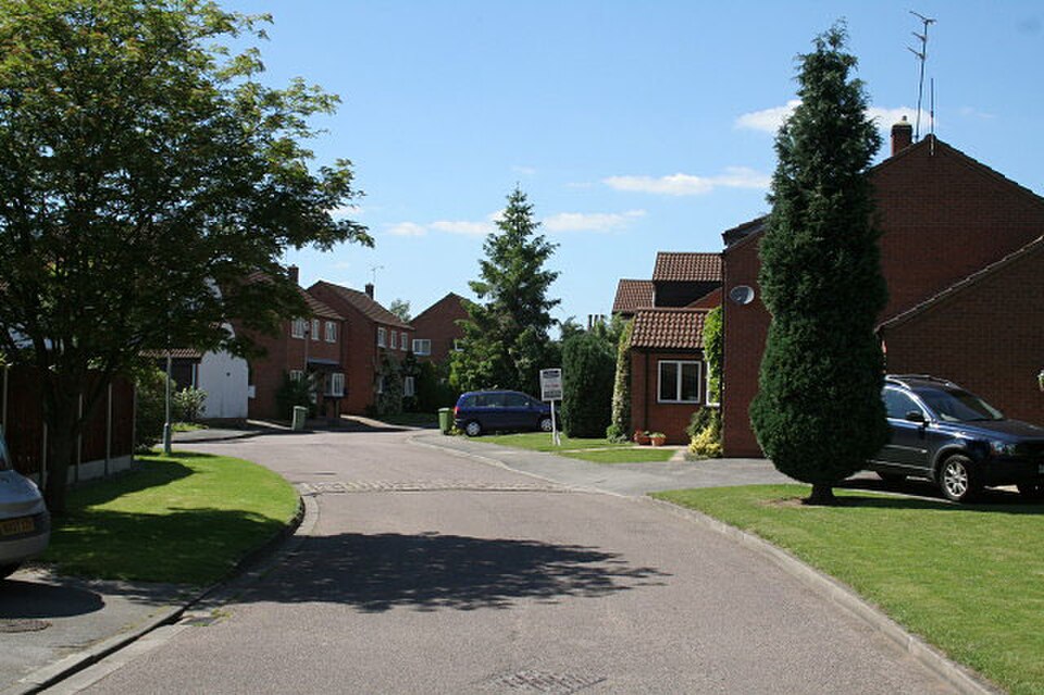 A view of the Riverside housing development built along the former railway alignment, with modern homes set beside a grassy embankment.