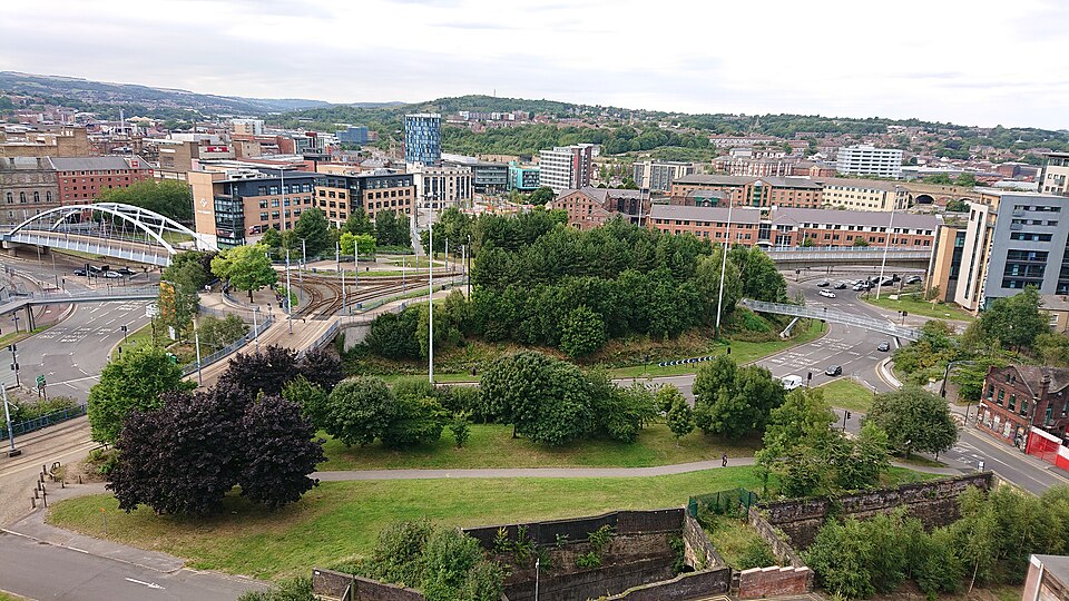 View of Park Square in Sheffield from Park Hill Flats, showing Park Square Bridge to the left and surrounding roads and greenery.